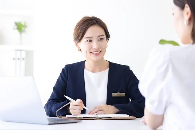 相談室で笑顔を見せながら会員と話す女性カウンセラー